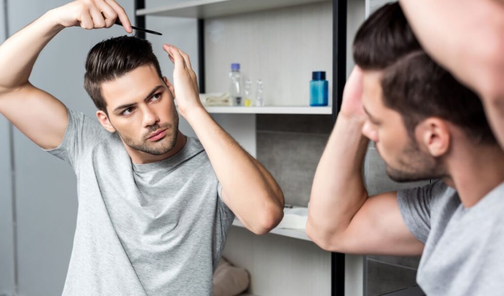A Man Combing His Hair in Front of the Mirror